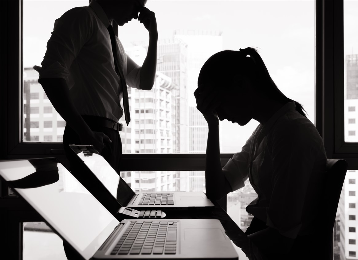 business people holding their hand to their head